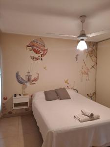 a bedroom with a white bed with a fish mural on the wall at Hermoso y luminoso departamento in Yerba Buena