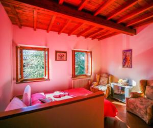 een woonkamer met roze muren en een tafel en stoelen bij Casolare Oltre il Cielo in Porcari