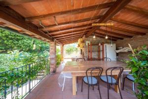 een terras met een houten tafel en stoelen bij Casolare Oltre il Cielo in Porcari