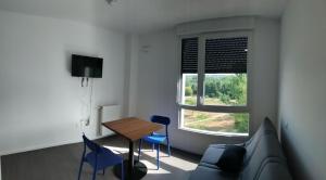 een woonkamer met een bank, een tafel en een raam bij A4-12 Studio cosy toulouse in Toulouse