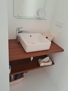baño con lavabo blanco en una estantería de madera en Deluxe Room Santa Barbara de Nexe, en Santa Bárbara de Nexe
