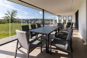 a dining table and chairs on the balcony of a house at Bedics Apartman in Szentgotthárd