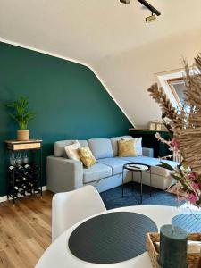a living room with a couch and a green wall at stilvoll-modern-neu - 15 min to Düsseldorf Messe in Meerbusch +19 photos