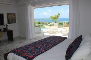 Un dormitorio con una cama con vista al mar. en Villa Fleurs de Lys, en Orient Bay 50 fotos más