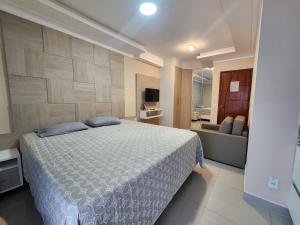 a bedroom with a large bed and a couch at Casamar Lofts, Praia dos Anjos Arraial do Cabo in Arraial do Cabo