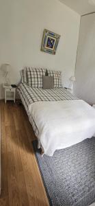 a bedroom with a large bed with white sheets at Deux pièces face aux pistes in Péone