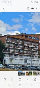 a large building with cars parked in front of it at Deux pièces face aux pistes in Péone