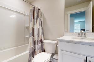 a white bathroom with a toilet and a sink at Hanahan Haven in Charleston +14 photos