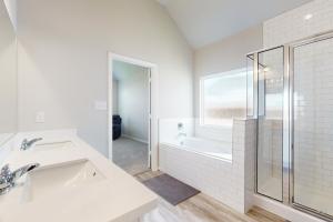 a white bathroom with a sink and a shower at The Berry Getaway in Humble +17 photos
