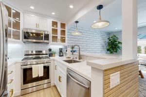 a kitchen with white cabinets and a sink at Mickey's Hideaway in Anaheim