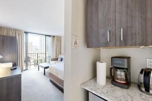 a hotel room with a kitchen and a bedroom at Palms at Waikiki #311 in Honolulu