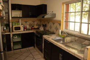 a kitchen with a sink and a stove and a microwave at La casa de la tía 3B Cuernavaca in Acapantzingo