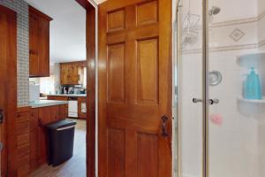 a bathroom with a wooden door and a kitchen at Cozy & Quiet Hyannis Retreat in Hyannis +17 photos