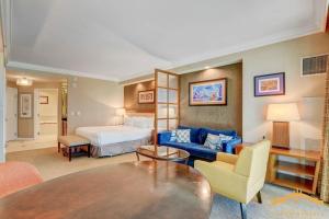 pokój hotelowy z łóżkiem i niebieską kanapą w obiekcie MGM Signature-22-809 F1 Track & Strip View Studio w Las Vegas