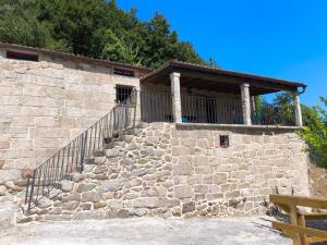 a stone building with a balcony on a stone wall at Xiravai-Ribeira Sacra in Peares