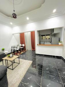 a living room with a table and a kitchen at Appartement Prestige Avec Balcon in Pointe-Noire +10 photos