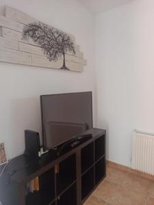 Una sala de estar con un televisor de pantalla plana en una pared. en Casa El Patio en Ronda, en Ronda