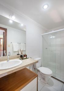 a bathroom with a sink and a toilet and a shower at Moderno 1 Quarto Dentro da Vila in Praia do Forte +8 photos