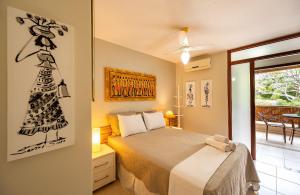 a bedroom with a bed with a drawing on the wall at Moderno 1 Quarto Dentro da Vila in Praia do Forte