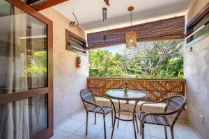 a balcony with a table and chairs and a window at Moderno 1 Quarto Dentro da Vila in Praia do Forte