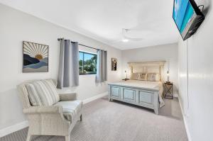 ボニータ・スプリングスにあるHeated Pool, Sleeps 10, Relaxing Lanai, Near Beaches, Pet Friendly!のベッドと椅子とテレビのある寝室