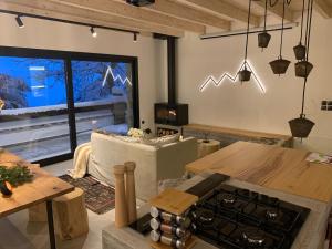 a living room with a table and a stove at The forest chalet in Parnassus in Eptalofos