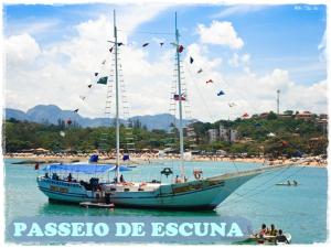 a large boat in the water next to a beach at Apt. de Setiba - HOSPEDARIA OCA RUCA in Guarapari