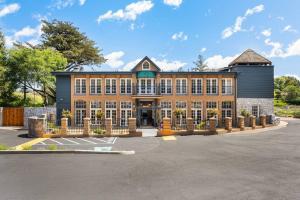a large brick building with a fence in a parking lot at Elegant Santa Rosa Getaway at Historic Stonehouse! in Santa Rosa +30 photos