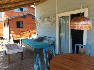 a porch with a bed and a table and chairs at Cabaña para 5 personas con vista al atardecer Cumbre del Diablo 4 in Punta Del Diablo