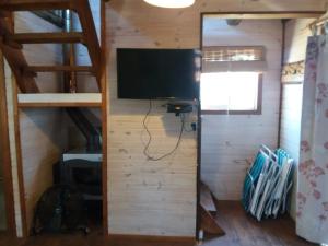 a living room with a tv and a wall with a sliding door at Cabaña para 5 personas con vista al atardecer Cumbre del Diablo 4 in Punta Del Diablo