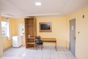 Barra do CordaHotel Diniz的房间里有一张桌子和一台挂在墙上的电视