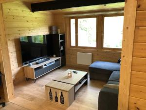 a living room with a couch and a television at Le Cottage de l etang in Bourbourg