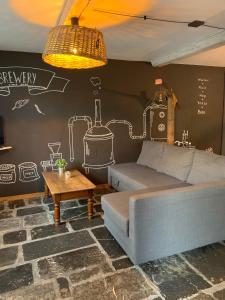 AubrivesにあるLes gîtes de la Brasserie d'Aubrives La Malterie et la Houblonnièreのソファと絵が描かれた壁のあるリビングルーム