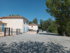 a car parked in front of a building with a fence at Appartement dans les vignes varoises in Brue-Auriac