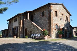 a building with two white chairs in front of it at Agriturismo Sant'Angelo in Acquapendente