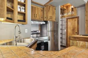 a kitchen with a sink and a stainless steel refrigerator at Whimsical Gatehouse at Dark Horse Estate in Franklin
