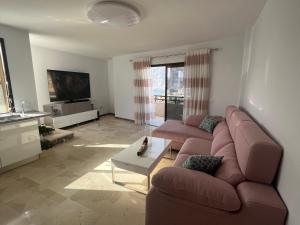 プエルト・デ・サンティアゴにあるRoom in 4 bedroom penthouse with stunning patioのソファとテーブルのあるリビングルーム