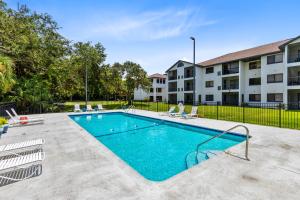 a swimming pool with chairs and a building at Oasis 105 - Blue Bliss in Titusville