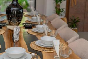a long wooden table with plates and glasses on it at Villa vue atlas marrakech in Marrakech