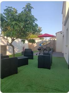 a yard with chairs and a table and a tree at Maison aux portes de La Rochelle in La Jarrie +1 photo