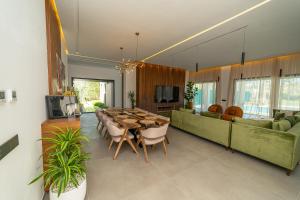 a dining room with a long table and a green couch at Villa vue atlas marrakech in Marrakech