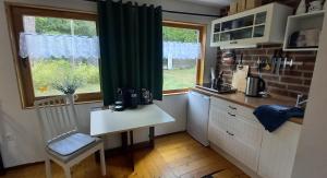 eine kleine Küche mit Tisch und Fenster in der Unterkunft Seeidyll in Heidesee + 7 Fotos