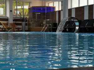 a swimming pool with a water feature in a hotel at Hotel Pilot in Cazin