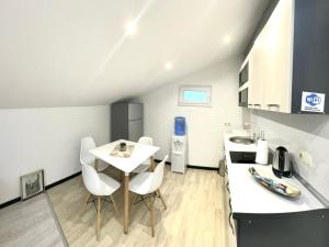 a kitchen with a white table and chairs in a room at Apartman Amina in Mostar