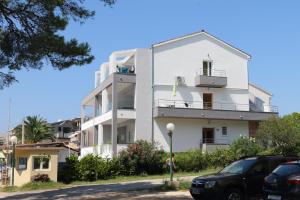 a white building with cars parked in front of it at Apartmani Mary S2 in Kukljica