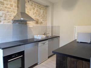 a kitchen with a sink and a counter top at La porterie in Bignoux