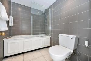a bathroom with a white toilet and a bath tub at Charming 3 Bed Luxury Flat in Central London in London