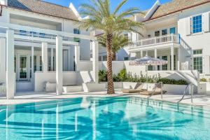 una piscina davanti a una casa con una palma di Kaiya Beach Resort a Inlet Beach