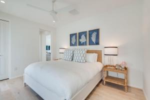 una camera da letto bianca con un letto grande e due lampade di Kaiya Beach Resort a Inlet Beach Altre 9 foto