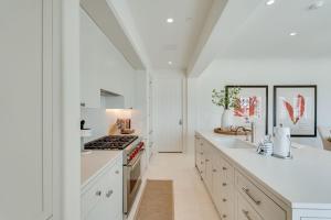 una cucina con mobili bianchi e un forno a piano cottura di Kaiya Beach Resort a Inlet Beach